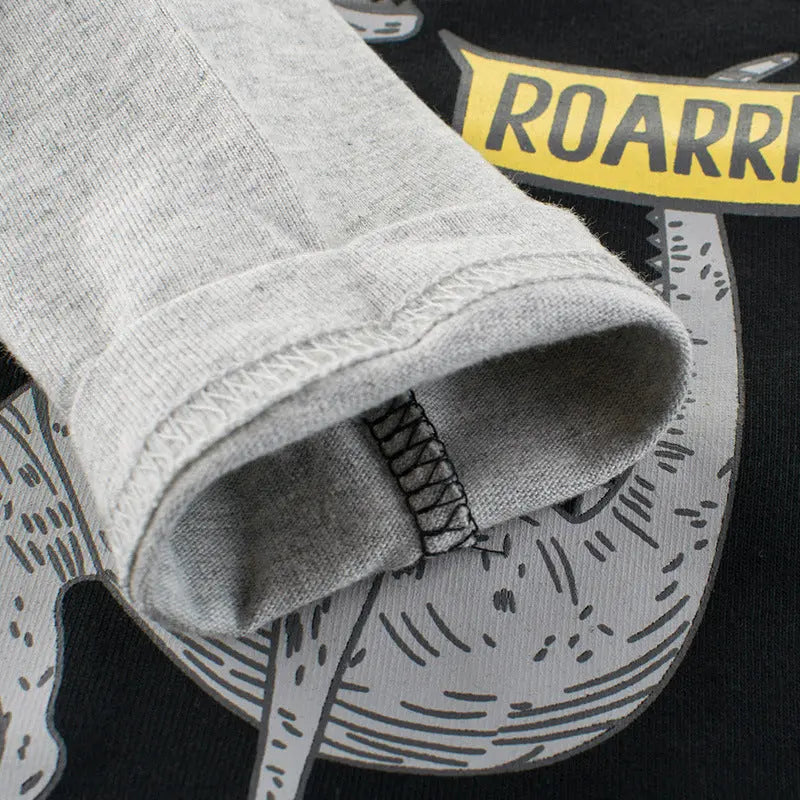 Close-up of the sleeve on the black 'Let's Play! ROARRR' long sleeve kids' t-shirt, showcasing the soft and comfortable cotton fabric.