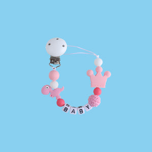 Pink Little Dino Silicone Pacifier Chain with a secure Hemu pacifier clip and a playful dinosaur design.